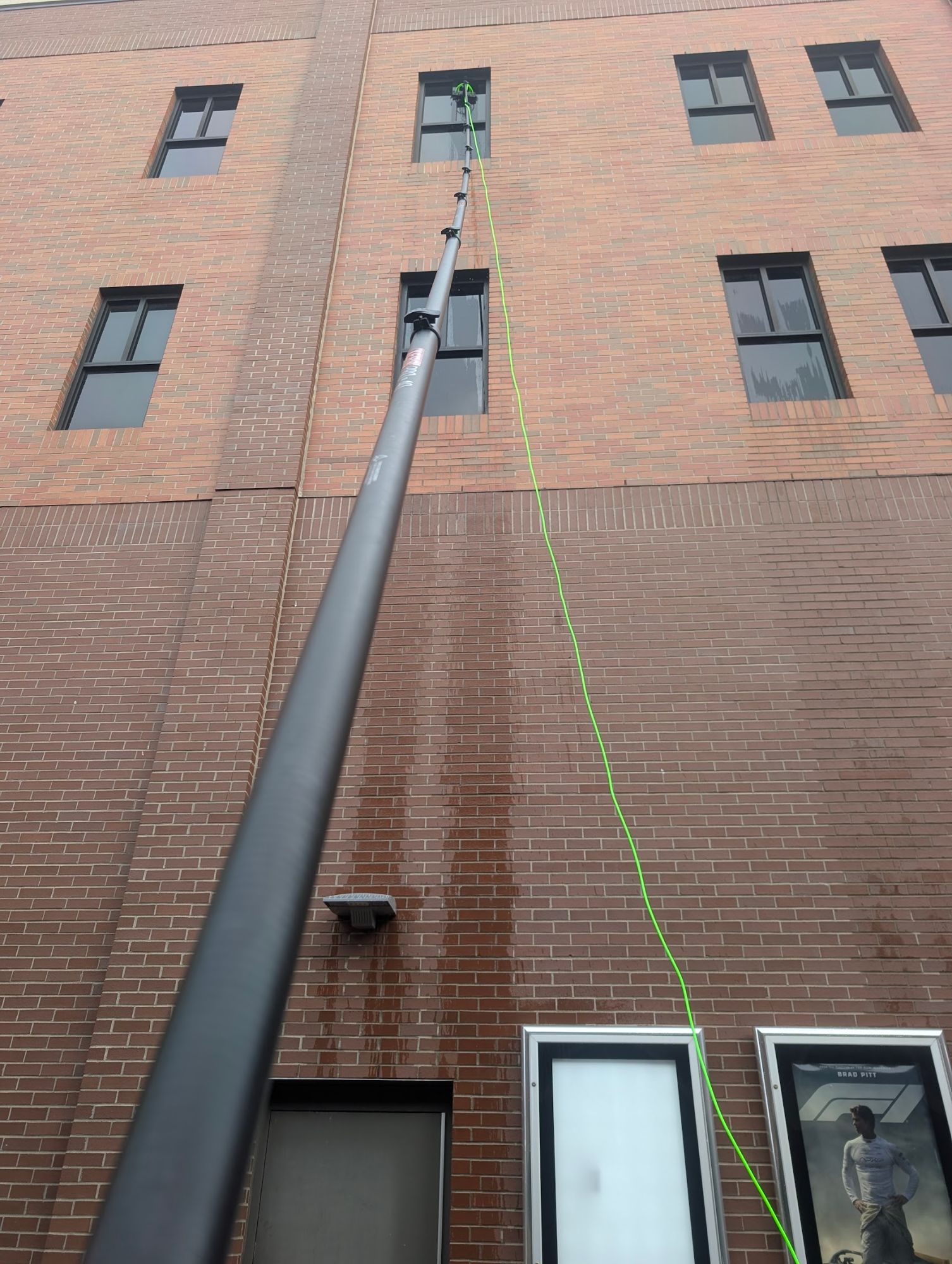 Water-fed pole window washing on a multi-story commercial building