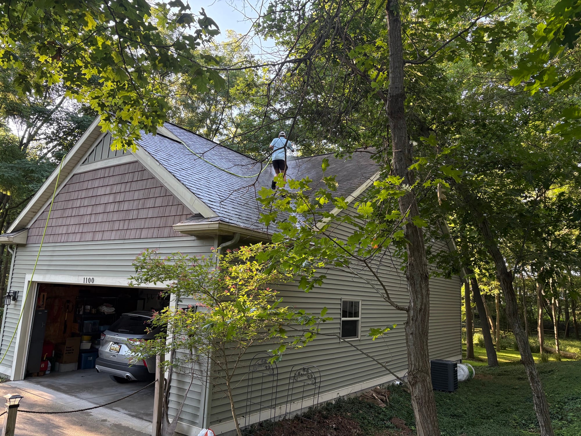 Technician soft washing a roof in Grand Rapids